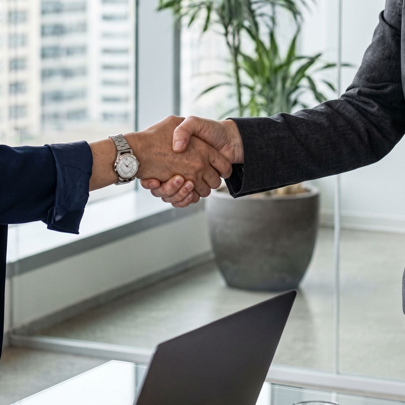 A handshake between two professionals in a bright office